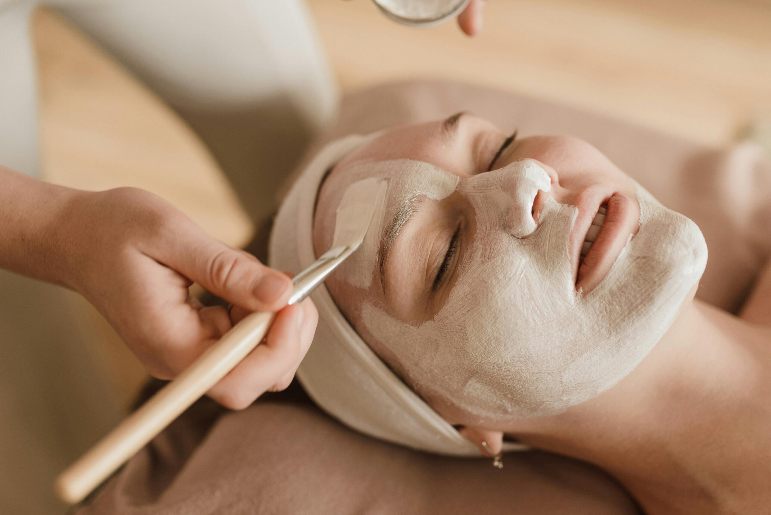Pose de produit crémeux sur le visage d'une femme
